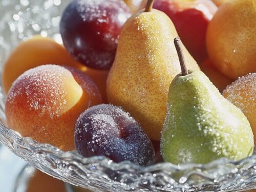Sugared fruit in glass bowl: pears, apples, plums, and peaches with sparkling coating