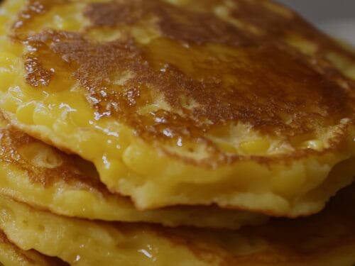 Close-up of stacked golden pancakes dusted with cinnamon sugar
