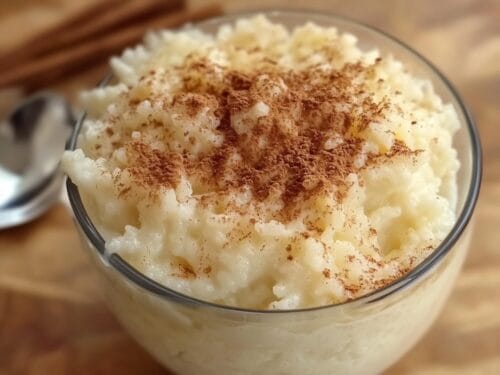 Creamy pudding topped with cinnamon and sugar crystals in a glass bowl
