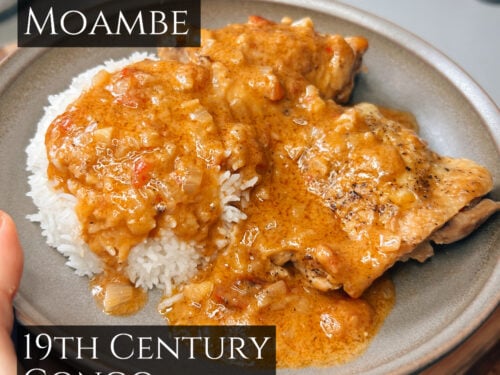 Chicken moambé, golden-brown sauce with white rice on gray ceramic plate