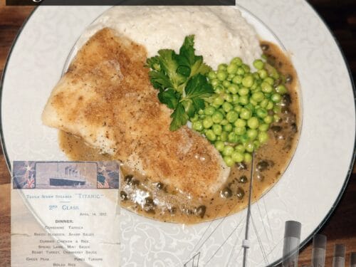 Baked fish fillet with brown sauce, peas, and parsley on white plate