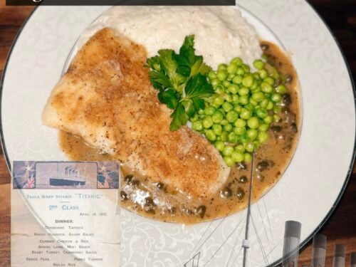 Fish fillet with brown crust, capers, peas, and parsley on white plate