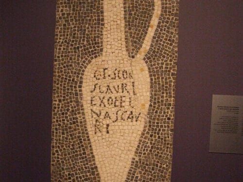 Mosaic tile panel depicting a tall narrow vessel with Latin text inscribed on its body