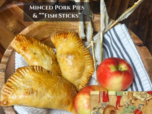 Golden-brown hand pies on wooden plate with two red apples and striped linen cloth