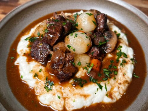 Braised beef chunks and pearl onions on creamy mashed potato base, topped with parsley