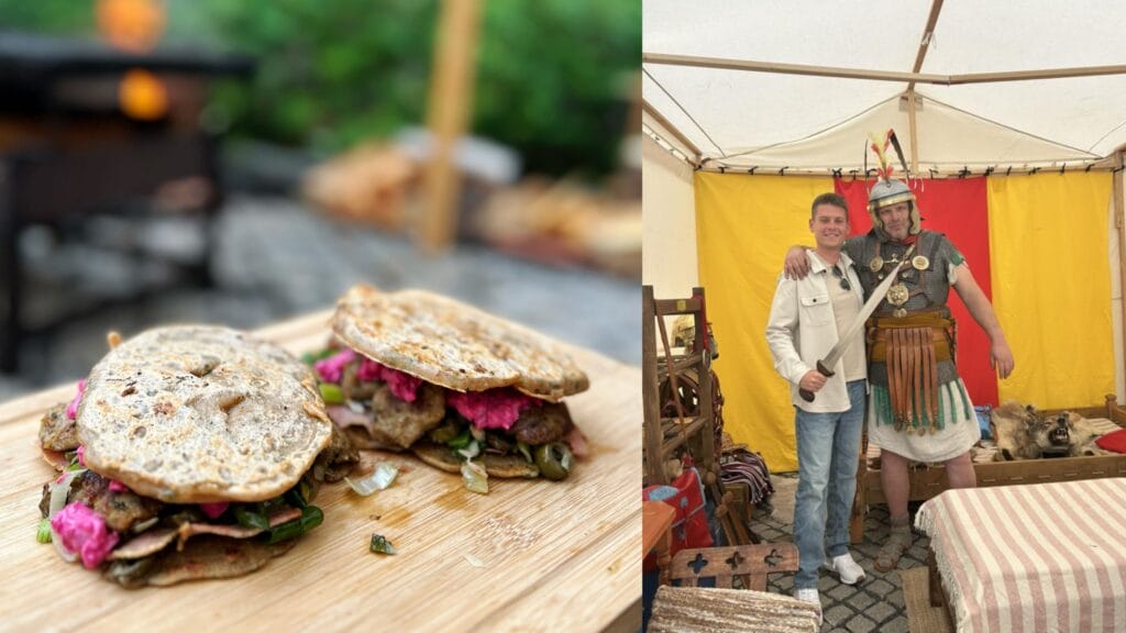 Two sandwiches on seeded buns with meat and pink flowers, on wooden board